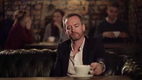 Businessman thinking and drinking coffee in cafe 库存影片 69964498