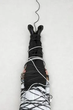 Businessman tied up with computer cable, elevated view Stock Photos