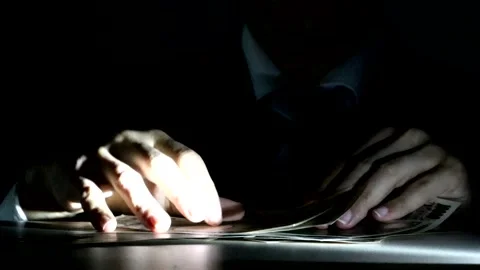 A businessman touching banknotes in the dark Stock Footage 334916054