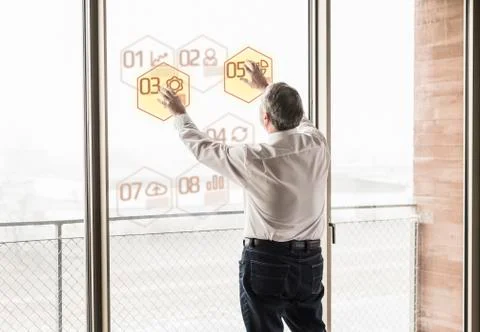Businessman touching windowpane with data in office Stock Photos