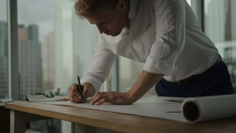 Businessman traces a project in office with view on downtown LA and skyscrapers Stock-Footage 127412372
