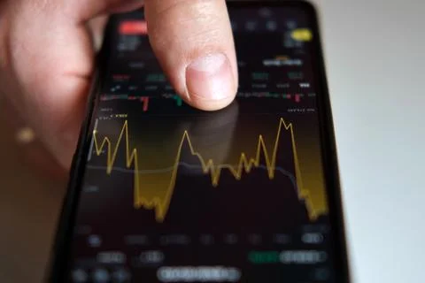 Businessman trader using smartphone checking stock exchange. Man using mobile Stock Photos