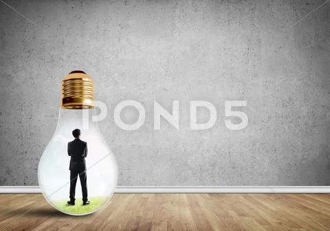Businessman trapped in bulb Stock Photos