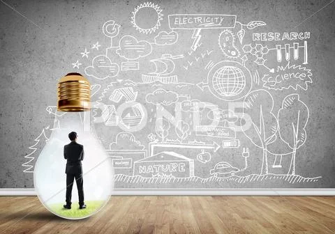 Businessman trapped in bulb Stock Photos