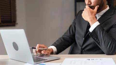 Businessman typing data on laptop while thinking and analyzing strategy of .. Stock Photos