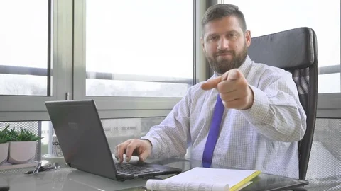 Businessman typing on laptop computer points the finger at camera, in office Vidéo 73169178