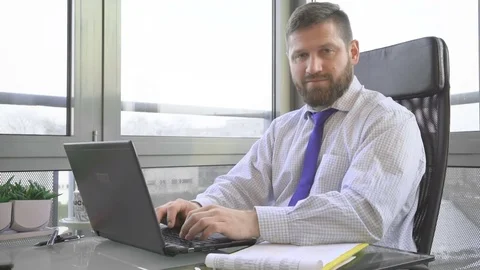 Businessman typing on laptop computer shows ok at camera in office Vídeo Stock 73169166