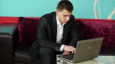 Businessman typing on notebook and looking away Stock Footage 22769173