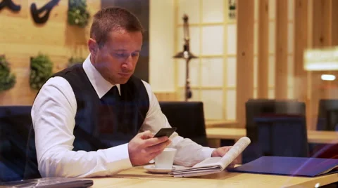Businessman typing sms regarding advertisement in the cafe, steadycam shot 스톡 동영상 44189191