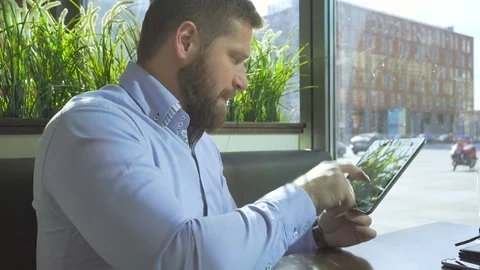 Businessman typing on tablet, look at camera, close profile steadicam Vidéo 73316805