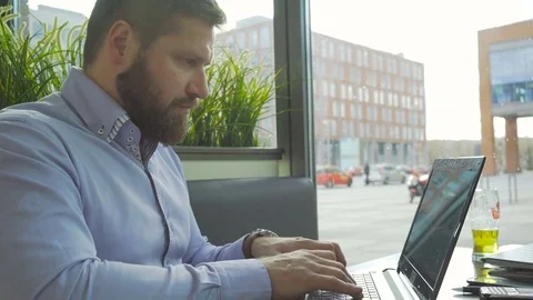 Businessman typing, writing on laptop computer, in cafe, profile close steadicam 库存影片 73299784