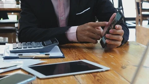Businessman use a smartphone to explain the job or share idea in meeting. Stock Footage 115591053