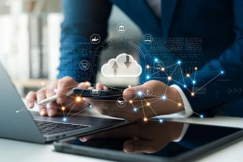 Businessman uses cloud computing technology through laptop and tablet. Stock Photos