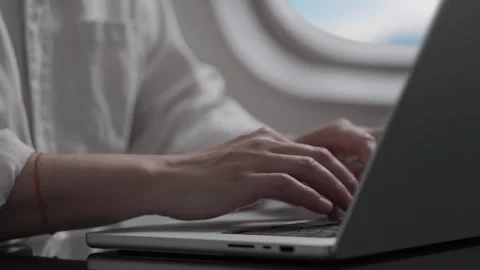A businessman uses a laptop while flying on an airplane. Stock Footage 278158813