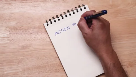 Businessman using blue ink gel pen writing ACTION PLAN list in notebook Video stock 199436166