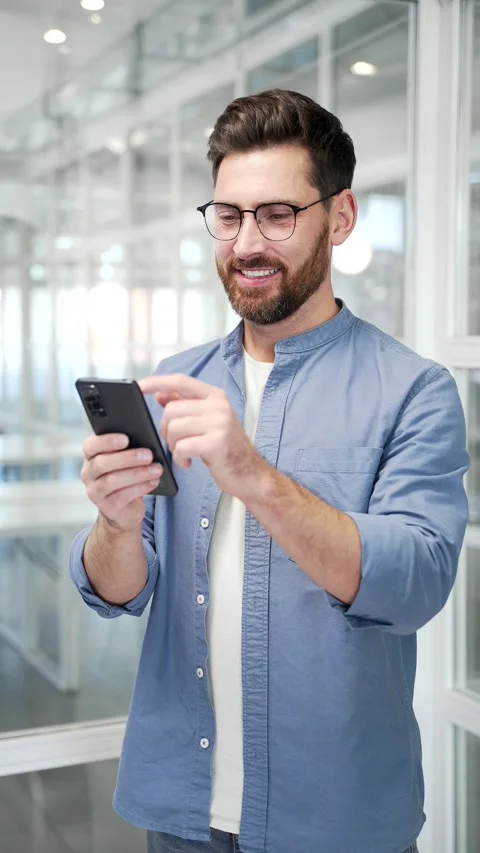 Businessman is using browsing mobile phone standing at workplace  Stock Footage 319775107