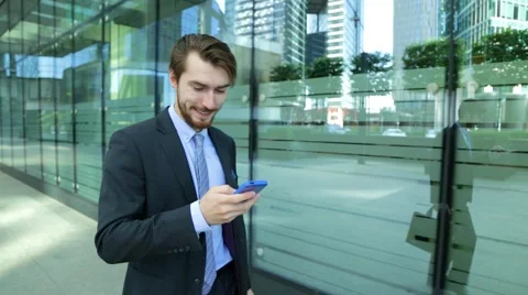 Businessman is using business app on smart phone walking in city Stock Footage 67235532