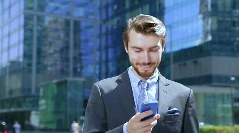 Businessman is using business app on smart phone in city, texting sms Stock Footage 67583385