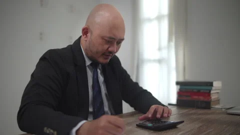 Businessman Using Calculator and Writing Financial Notes at Office Desk Stock Footage 336870336