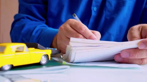 Businessman using calculator and writing notes in notepad at desk Stock Footage 337671755