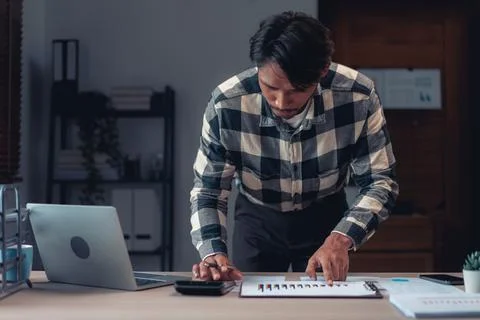 Businessman using calculator to checking financial and accounting report of.. 写真素材