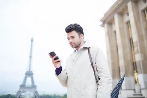 Businessman using cell phone by Eiffel Tower, Paris, France 写真素材