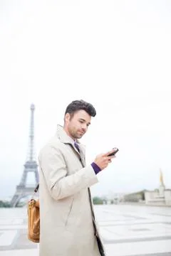 Businessman using cell phone by Eiffel Tower, Paris, France 写真素材