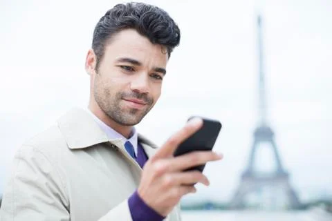 Businessman using cell phone by Eiffel Tower, Paris, France 写真素材