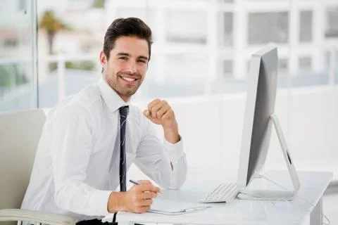 Businessman using computer and taking notes 스톡 사진