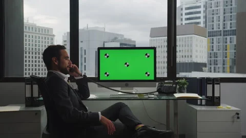 Businessman using a computer with green screen and talking on the phone Stock Footage 264244533