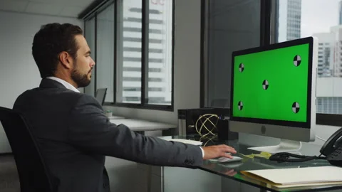 Businessman using a computer with green screen in modern office Stock Footage 264247087