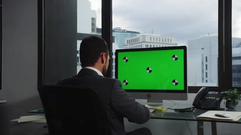 Businessman using a computer with green screen in his office Stock Footage 264248339