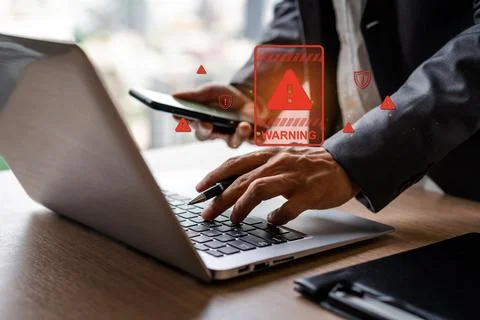 Businessman using computer laptop with caution warning sing Photos