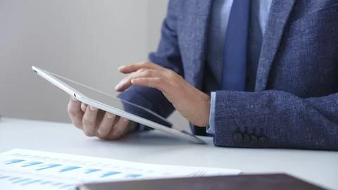 Businessman is using a digital tablet to analyze financial data, working with Stock Photos