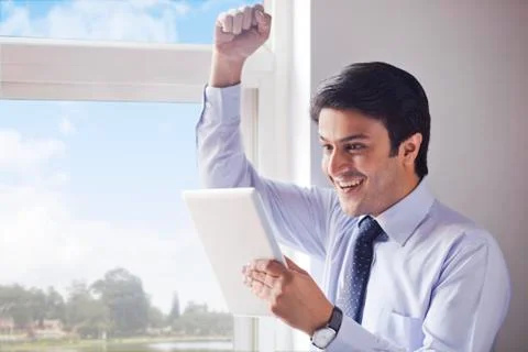 Businessman using a digital tablet and looking excited Stock Photos