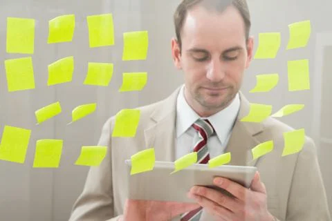 Businessman Using Digital Tablet In Front Of Adhesive Notes On Glass Wall Stock Photos