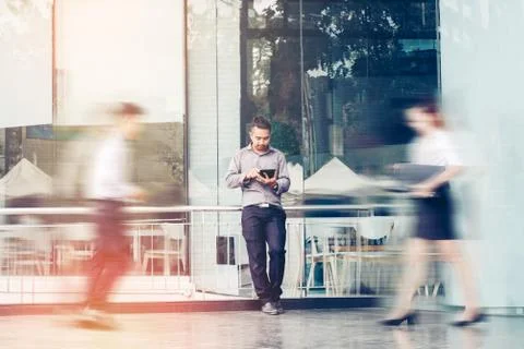 Businessman using a digital tablet office outdoors and Blurred People Walking Stock Photos