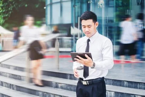 Businessman using a digital tablet office outdoors and Blurred People Walking Stock Photos