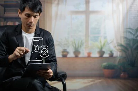 Businessman Using Digital Tablet with Security Icons in Modern Indoor Setting Stock Photos