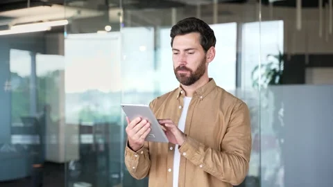 Businessman is using digital tablet standing in modern business office. Handsome Video stock 316679061