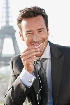 Businessman using a hands-free device with the Eiffel Tower in the background, Stockfoto's