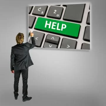 Businessman using a Help key on a computer Stock Photos