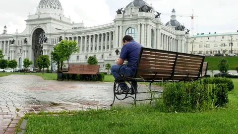 Businessman using his cellphone and sitting on a bench in Kazan city. 3840x2160 Stock-Footage 80461004