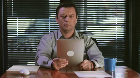 A businessman using his tablet while talking over a video chat 스톡 동영상 33841724