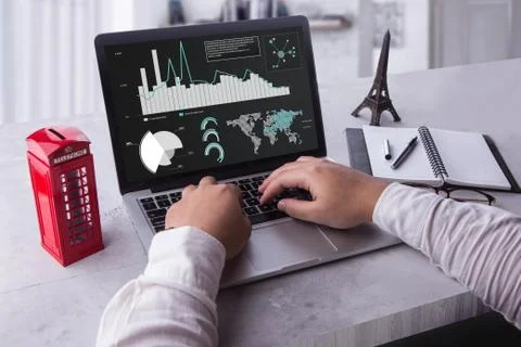 Businessman using laptop analyzing statistics data on laptop screen, working wit Stock Photos