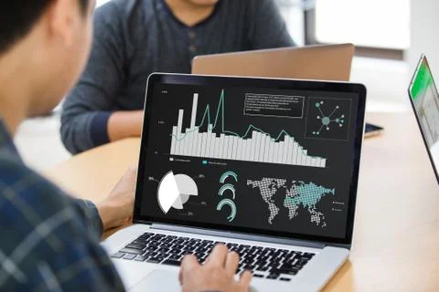Businessman using laptop analyzing statistics data on laptop screen, working wit Stock Photos