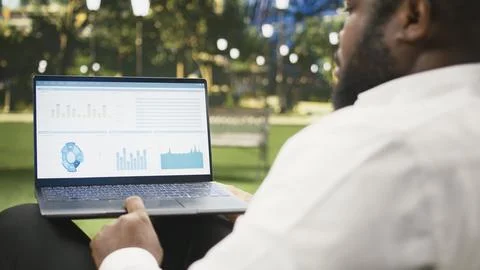 Businessman using laptop and analyzing charts and performance dashboards 库存照片