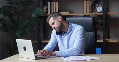 Businessman using laptop and calling smartphone in same time working overtime in Stock Footage 159753265