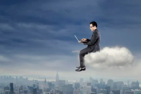 Businessman using laptop on the cloud Foto stock