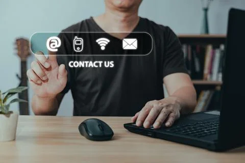 Businessman using laptop computer and touch on virtual screen contact icons.. Stock Photos